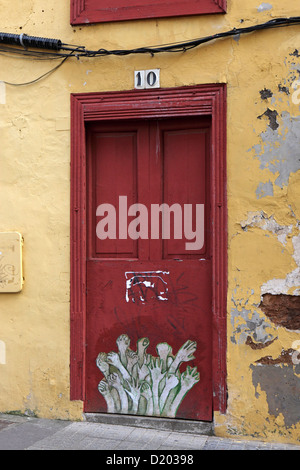 Porte peinte, Funchal, Madère, la porte rouge, avec de l'orange-jaune paster entourent plus des signes avec la main Banque D'Images