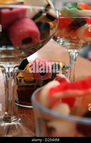 Une sélection de bonbons dans des pots en verre et les verres de champagne Banque D'Images