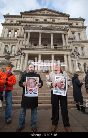 Lansing, Michigan - Le jour de l'ouverture de la session législative de 2013 dans le Michigan, les membres de l'Union européenne l'entrée de ligne de la capitale de l'Etat dans ce qu'ils appelaient une marche de la honte. Ils protestaient contre un "droit au travail" qui a été à la hâte dans les derniers jours de la session législative de 2012. Beaucoup d'entre eux tenu photos de législateurs républicains qui ont voté pour la loi. Banque D'Images