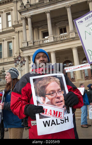 Lansing, Michigan - Le jour de l'ouverture de la session législative de 2013 dans le Michigan, les membres de l'Union européenne l'entrée de ligne de la capitale de l'Etat dans ce qu'ils appelaient une marche de la honte. Ils protestaient contre un "droit au travail" qui a été à la hâte dans les derniers jours de la session législative de 2012. Beaucoup d'entre eux tenu photos de législateurs républicains qui ont voté pour la loi. Banque D'Images