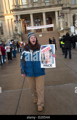 Lansing, Michigan - Le jour de l'ouverture de la session législative de 2013 dans le Michigan, les membres de l'Union européenne l'entrée de ligne de la capitale de l'Etat dans ce qu'ils appelaient une marche de la honte. Ils protestaient contre un "droit au travail" qui a été à la hâte dans les derniers jours de la session législative de 2012. Beaucoup d'entre eux tenu photos de législateurs républicains qui ont voté pour la loi. Banque D'Images