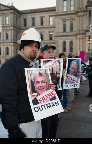 Lansing, Michigan - Le jour de l'ouverture de la session législative de 2013 dans le Michigan, les membres de l'Union européenne l'entrée de ligne de la capitale de l'Etat dans ce qu'ils appelaient une marche de la honte. Ils protestaient contre un "droit au travail" qui a été à la hâte dans les derniers jours de la session législative de 2012. Beaucoup d'entre eux tenu photos de législateurs républicains qui ont voté pour la loi. Banque D'Images