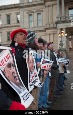 Lansing, Michigan - Le jour de l'ouverture de la session législative de 2013 dans le Michigan, les membres de l'Union européenne l'entrée de ligne de la capitale de l'Etat dans ce qu'ils appelaient une marche de la honte. Ils protestaient contre un "droit au travail" qui a été à la hâte dans les derniers jours de la session législative de 2012. Beaucoup d'entre eux tenu photos de législateurs républicains qui ont voté pour la loi. Banque D'Images
