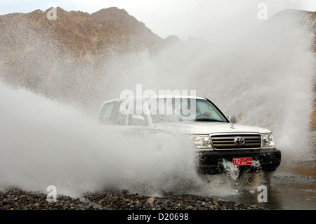 Wadi Bashing, Toyota véhicule hors route précipiter dans des flaques à Wadi Al Abyad, Al Batinah Région, Sultanat d'Oman Banque D'Images