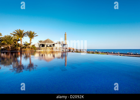 Piscine du Grand Hotel Costa et le phare sous ciel bleu, Meloneras, Maspalomas, Gran Canaria, Îles Canaries, Espagne, Europe Banque D'Images