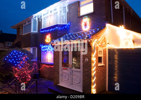 Illuminations de Noël. Comme la longue nuit d'hiver, les lumières de Noël festif à égayer cette maison jumelée à Dorchester, Dorset, Angleterre. UK. Banque D'Images