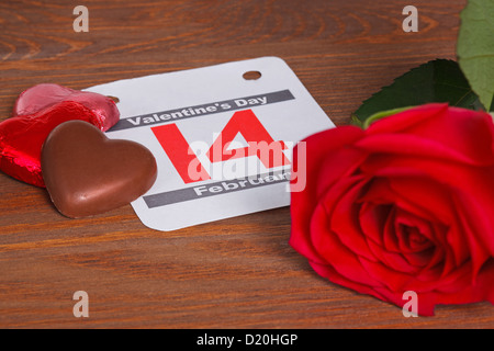 Valentines Day still life photo avec une date du calendrier pour le 14 février avec une rose rouge et chocolats en forme coeur Banque D'Images