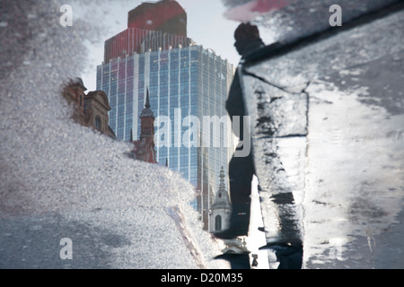 99 Bishopsgate Tower 42 Natwest et l'homme reflet dans flaque londres Banque D'Images