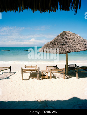 Des parasols et des lits traditionnels faits de cordes de coco pour les clients, plage de Blue Oyster Hotel, Jambiani, au sud-est de Zanzibar, Banque D'Images