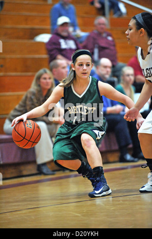 Player tire sur son dribble comme elle voit une route vers le panier est interrompre par la défense au cours des études secondaires en jeu. USA. Banque D'Images