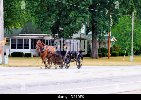 USA , Indiana, Middlebury, Elkhart Comté. Buggy Amish plein de membres de la famille est entraîné dans la rue principale Banque D'Images