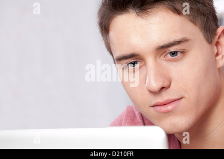 Gros plan d'un jeune homme à l'aide d'un ordinateur portable ou tablette numérique. Banque D'Images