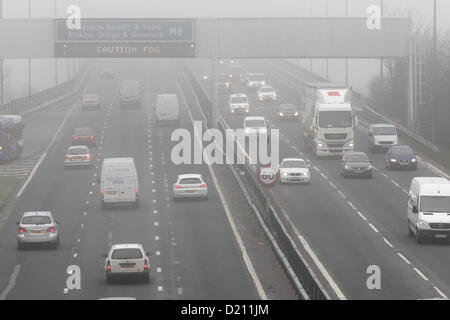 White Cart Viaduct, Arkleston, Renfrewshire, Écosse, Royaume-Uni, jeudi 10 janvier 2013. Trafic traversant le brouillard sur l'autoroute M8 avec attention brouillard affiché sur un panneau LED du statif au-dessus Banque D'Images