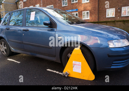 Une voiture en stationnement illégal qui a été fixé à la roue. Banque D'Images