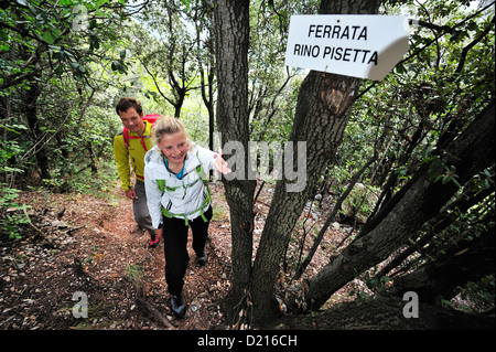 Jeune femme et jeune homme par forêt pour route de corde fixe Rino Pisetta, Lago die Toblino, Sarche, Calavino, Trentin Banque D'Images