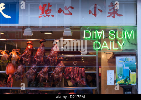 Fenêtre d'un restaurant chinois dans China Town, Queen Street Soho Londres UK avec des canards qui pendent et signes dim sum Banque D'Images