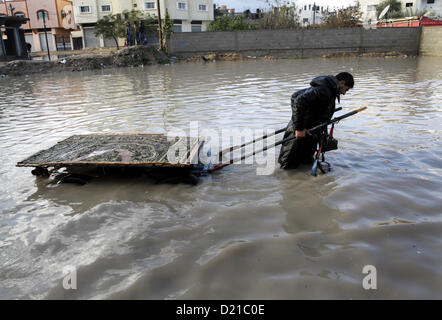 10 janvier 2013 - La ville de Gaza, bande de Gaza, territoire palestinien - un Palestinien remorque une panier dans une rue inondée après un des pluies torrentielles. (Crédit Image : © Sameh Rahmi/APA Images/ZUMAPRESS.com) Banque D'Images