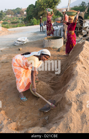 Les Indiens le mélange du sable et du ciment pour la fabrication de blocs de béton. L'Andhra Pradesh, Inde Banque D'Images