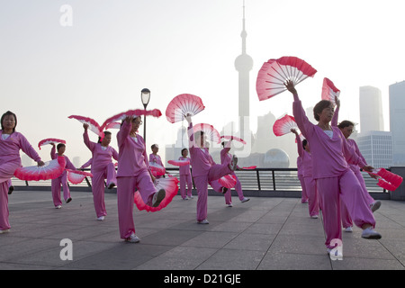 Exercices du matin, les femmes qui font la danse du ventilateur au Bund le matin, Shanghai, Chine Banque D'Images