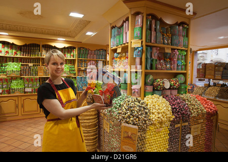 Vendeuse montrant des sucreries pour vente à La Cure Gourmande Biscuitier Sucrecuitier candy shop, Strasbourg, Alsace, France, Europe Banque D'Images