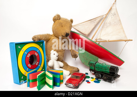 Une collection de bien-aimé simple classique des jouets d'enfants dont un mignon petit ours en peluche, en bois rouge, bateau à voile, et train vert Banque D'Images