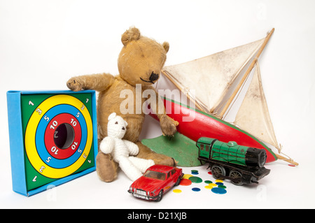 Une collection de bien-aimé simple classique des jouets d'enfants dont un mignon petit ours en peluche, en bois rouge, bateau à voile, et train vert Banque D'Images