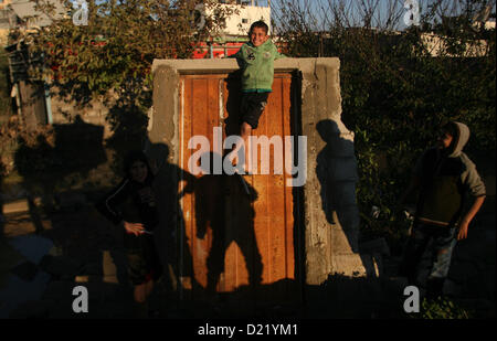 11 janvier 2013 - Rafah, bande de Gaza, territoire palestinien - enfants palestiniens jouer sur une maison détruite après les fortes tempêtes de la porte du camp de réfugiés de Rafah, dans le sud de la bande de Gaza le 11 janvier 2013. À Gaza, le temps froid et la pluie a inondé plusieurs des tunnels entre le territoire et l'Egypte comme dans la ville de Ramallah, en Cisjordanie, les enfants et les adultes, y compris certains policier arrêté leur cruiser pour une bataille de boules de neige impromptue (crédit Image : © Eyad Al Baba/APA Images/ZUMAPRESS.com) Banque D'Images