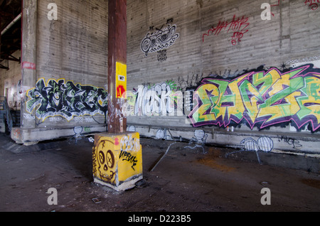 Les murs d'un entrepôt désaffecté sont couverts de graffitis colorés. Banque D'Images