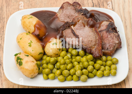 Les côtelettes d'agneau aux pois, les pommes de terre et sauce - studio shot Banque D'Images