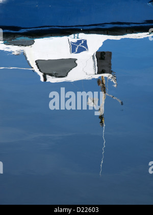 Un petit bateau de pêche se reflète dans les eaux calmes du Port de Cromarty dans les Highlands et les Îles. Banque D'Images