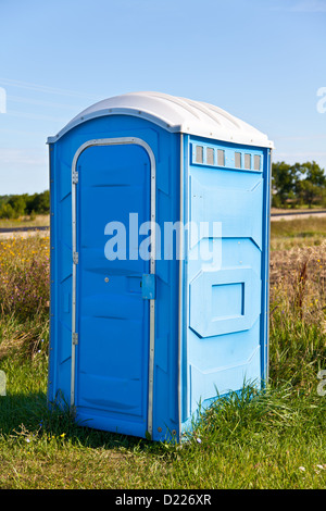 Bleu une toilette portative dans l'herbe. Banque D'Images