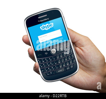 Une personne titulaire d'un téléphone intelligent Blackberry 9000 isolé en fond blanc Banque D'Images