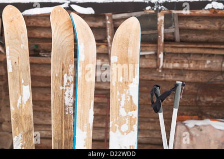 Deux paires de skis larges et log mur de la maison en hiver jour Banque D'Images