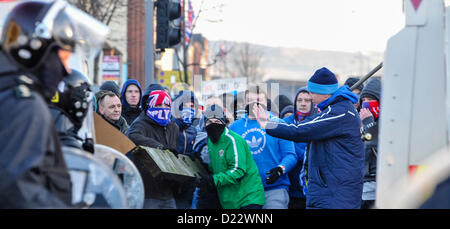 12 janvier 2013, Belfast, Irlande du Nord. Un homme tente d'arrêter les émeutiers à l'aide d'une grosse poutre de bois à ram. agents PSNI Il s'ensuit des affrontements entre loyalistes et des groupes nationalistes après une manifestation à Belfast City Hall. Briques, maçonnerie, lourd et d'artifice ont été lancés sur la police. Crédit : Stephen Barnes / Alamy Live News Banque D'Images