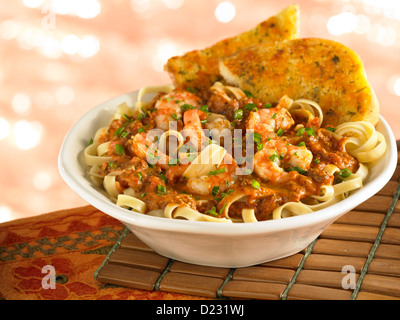 Pâtes aux crevettes servies avec du pain à l'ail Banque D'Images