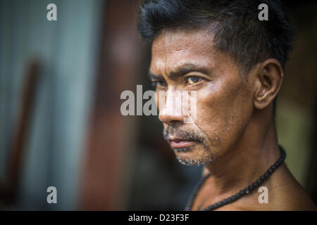 13 janvier 2013 - Bangkok, Thaïlande - un homme avec un ''sak yant'' ou saint tiger tatoo sur sa poitrine devant sa maison dans le quartier de Bangkok Bang Luang. Il croit que le tatouage lui permet de canaliser la puissance du tigre. Le quartier de Khlong Bang Luang lignes (Canal) Bang Luang dans la section de Thonburi Bangkok sur le côté ouest de la rivière Chao Phraya. Il a été établi à la fin du xviiie siècle par le roi Taksin le grand après les Birmans à sac la capitale Siamoise d'Ayutthaya. Le quartier, comme la plupart de Thonburi, est relativement peu développé et criss encore traversé par les canaux whic Banque D'Images