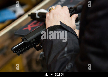 Un client interagit avec un revolver à un magasin d'armes à feu. Banque D'Images