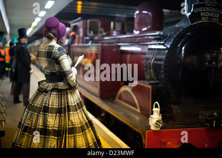 La station de métro Moorgate, Londres, Royaume-Uni. 13 Jan, 2013. Photo montre une dame en costume victorien sur la plate-forme à la 150e anniversaire du premier chemin de fer souterrain lorsque le voyage initial a eu lieu en 1863. Le premier voyage a été recréé à l'aide d'une locomotive restaurée et un vieux Metropolitan Transport ferroviaire de Paddington à Farringdon. Banque D'Images