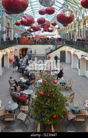 Consommateurs et aux touristes au café avec arbre de Noël et autres décorations saisonnières marché couvert de Covent Garden London England UK Banque D'Images