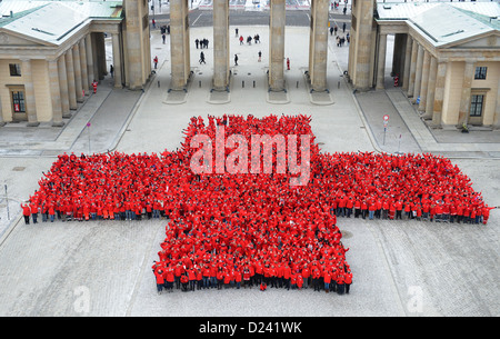 1 800 membres de la Croix-Rouge allemande (DRK) vêtus de rouge forme une grande croix à la porte de Brandebourg à Berlin, Allemagne, 13 janvier 2013. La performance faisait partie de l'année du 150e anniversaire du Canada. Photo : Britta Pedersen Banque D'Images