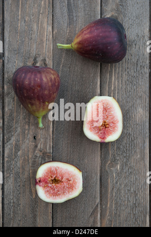 Les figues coupées en deux sur une planche de bois. Banque D'Images