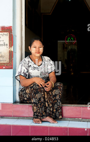 Une femme portant thanaka birmane crème cosmétique assis sur une étape à la pagode Sule, Yangon, Birmanie Banque D'Images