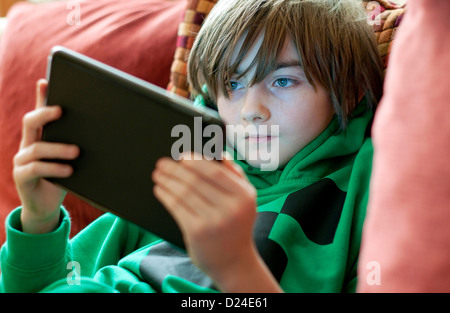 Jeune homme garçon à l'aide d'ipad mini tablet computer Banque D'Images