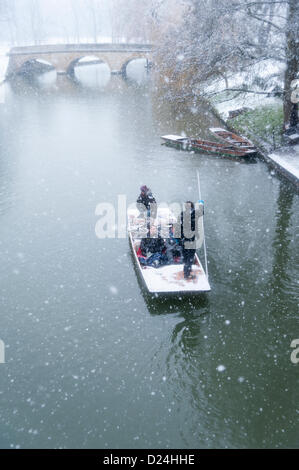 Cambridge UK 14 janvier 2013. Les gens en barque sur la rivière Cam, dans la neige. La neige épaisse est tombée au cours de l'après-midi à travers l'East Anglia et les touristes jouissent des paysages d'hiver le long du dos des collèges universitaires, en dépit du mauvais temps. Banque D'Images