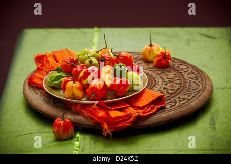 Un plat de piments Scotch Bonnet sur une planche en bois sculpté Banque D'Images