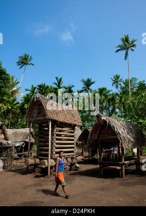 Kid en face d'une maison d'igname, îles Trobriand, Papouasie Nouvelle Guinée Banque D'Images