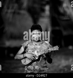 Jeune fille qui joue de la guitare, de l'île Trobriand, Papouasie Nouvelle Guinée Banque D'Images