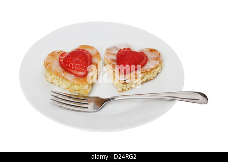 Deux gâteaux en forme de coeur avec une fourchette sur une assiette blanche contre isolés Banque D'Images