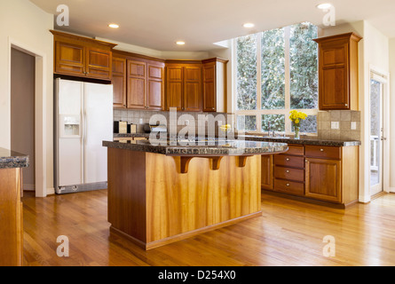 La lumière du jour moderne avec cuisine, parquet en chêne rouge massif armoires en bois de cerisier, de comptoir en pierre et cuisinière à gaz gamme dans l'île Centre Banque D'Images