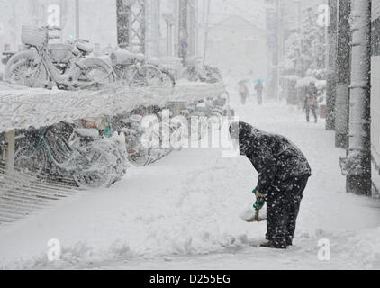 Tokorozawa, au Japon. 14 janvier 2013. Un homme s'attaque à une vaine tentative de pelleter la neige dans la région de Tokorozawa, banlieue ouest de Tokyo, le lundi 14 janvier 2013. Une tempête d'hiver freak pouces de neige, couvrant la zone métropolitaine de Tokyo et ses environs avec des couvertures de première neige de la saison. (Photo de Natsuki Sakai/AFLO) AYF -mis- Banque D'Images